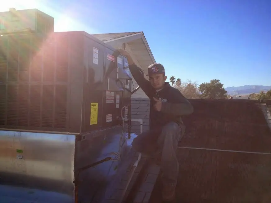 HVAC technician performing Boiler Repair on a rooftop unit in Ormond-by-the-Sea